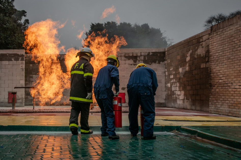 Firefighters extinguishing fire outside.